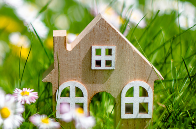 spring real estate market represented by a house with spring flowers